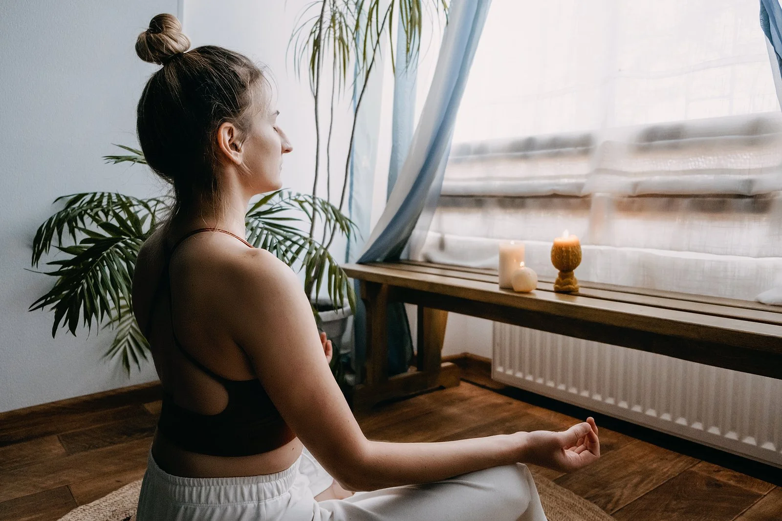  Woman doing yoga by a window. Yoga for pain in Austin, TX can help with chronic pain and more. Read on for thoughts from a yoga therapist in Austin here!  78701 | 78702 | 78732 