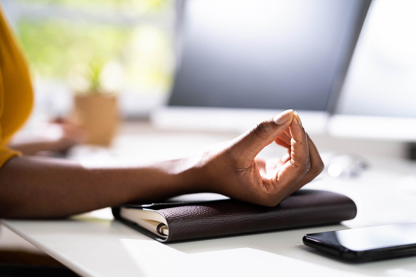  African American woman practicing breathing techniques to relax at work. If work life has become an experience full of stress and unmanaged anxiety we are here to help. Anxiety treatment in Austin, Tx can help you learn the skills to find calm again. 84060 - 84020 